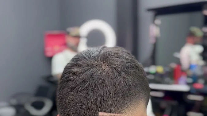 Detalle de un degradado hecho en 787 Barber Lounge: la transición del corte vista desde atrás bajo la luz del salón