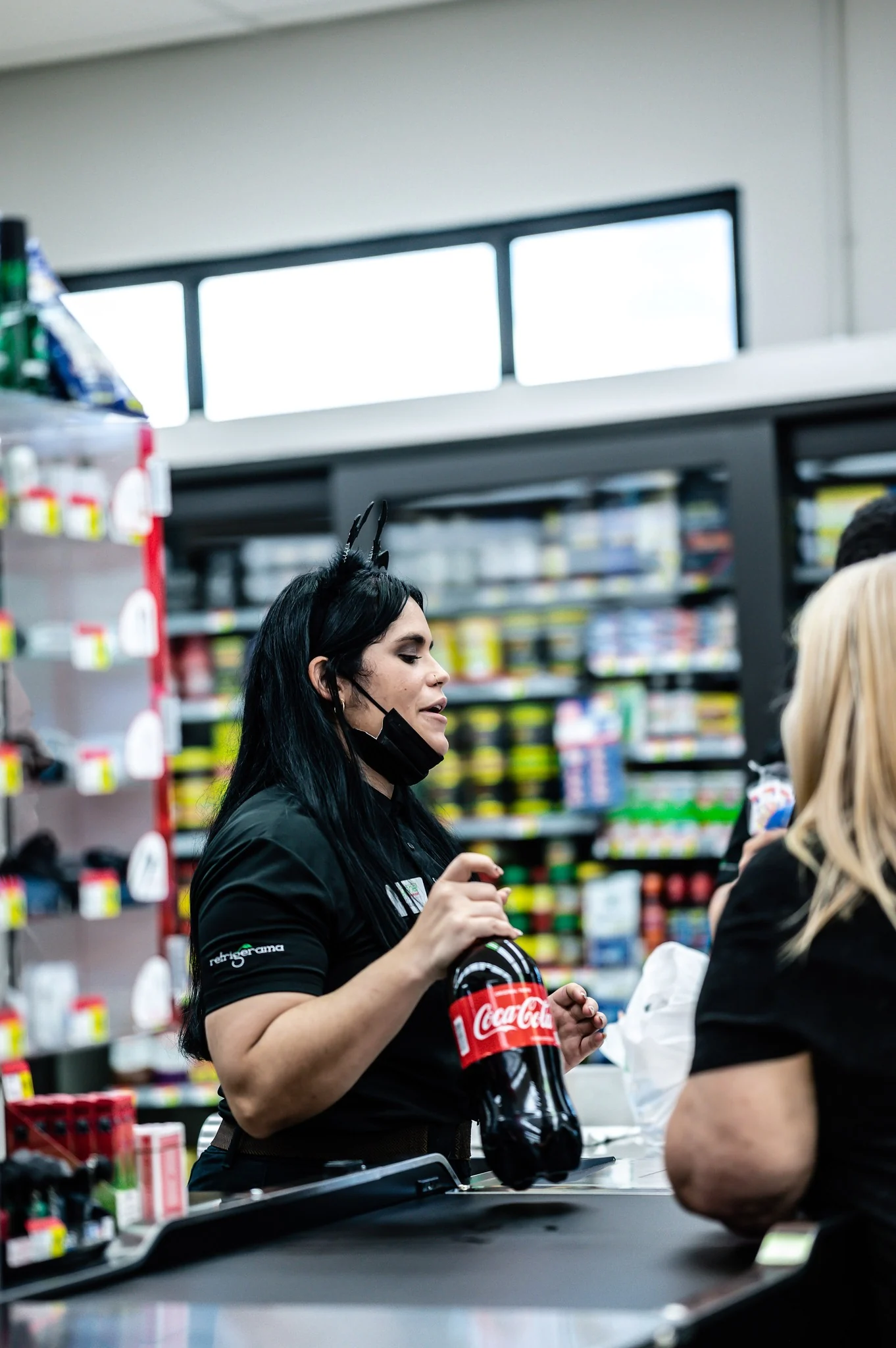 Cajera de Supermercados Agranel cobrando una Coca-Cola a una clienta — el equipo en su elemento