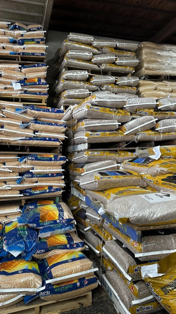Sacos de alimento y maíz apilados en el almacén