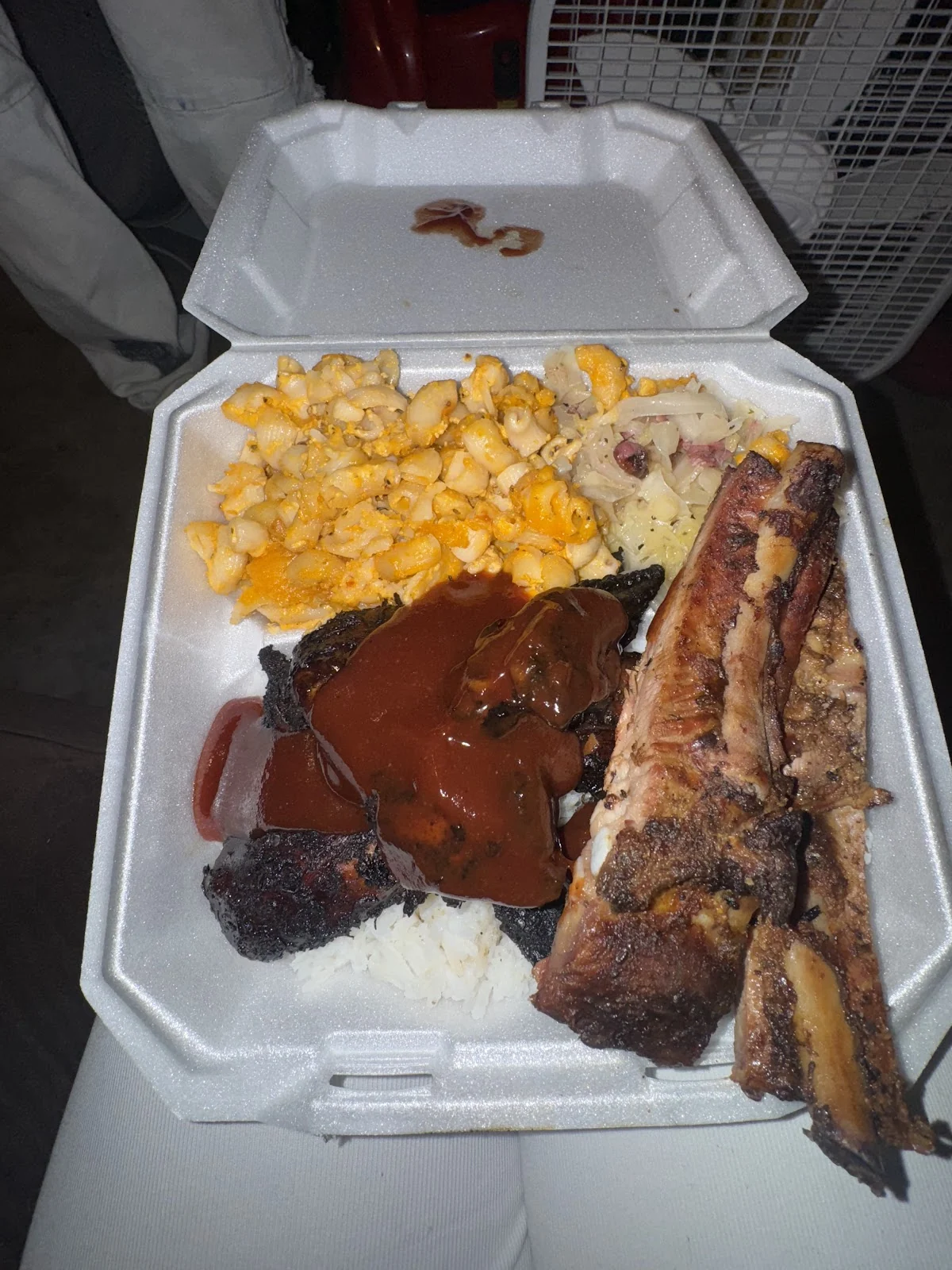Costillas BBQ y carne en salsa sobre arroz, con macaroni and cheese y repollo guisado