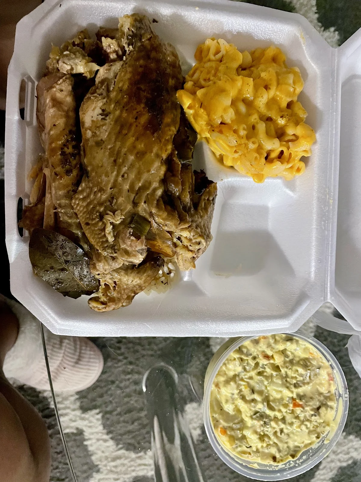 Alón de pavo guisado sobre arroz con macaroni and cheese y ensalada de papa