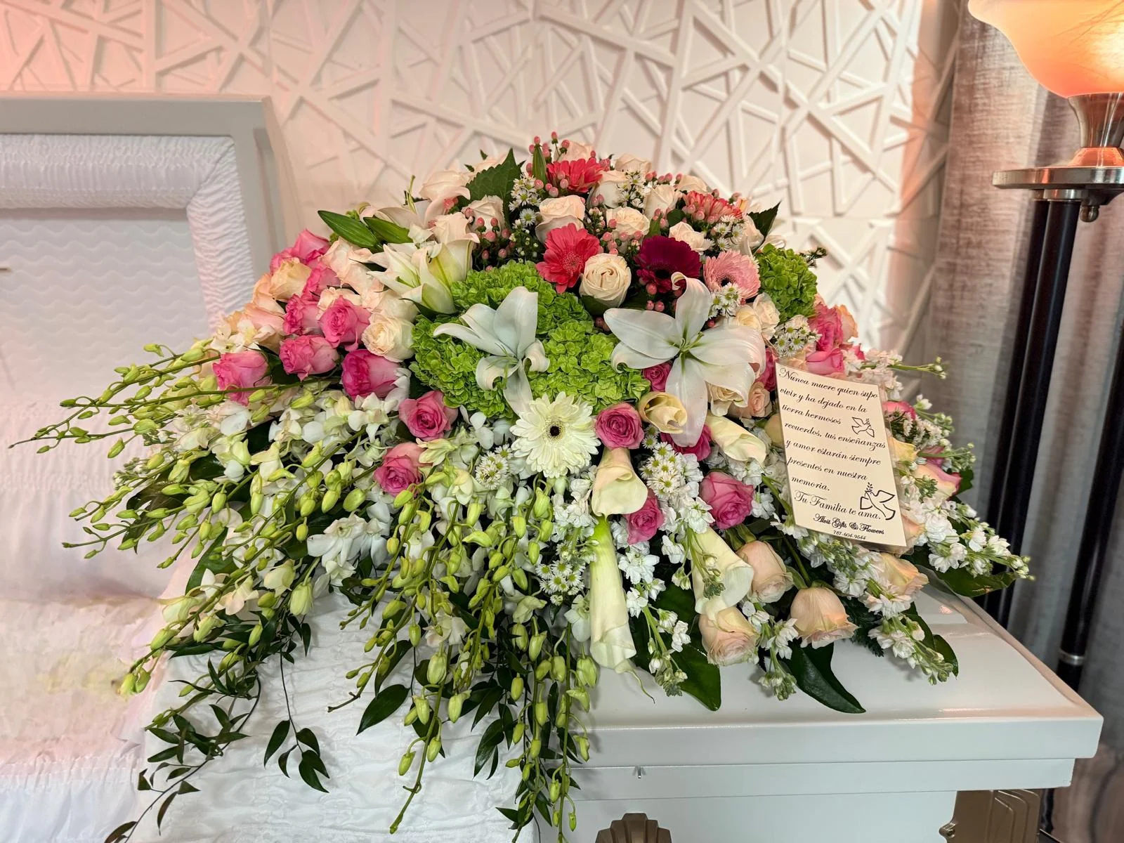 Casket cover de rosas rosadas, lirios blancos y hortensia verde con tarjeta de despedida