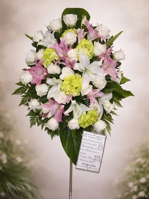 Corona de pie con lirios rosados, rosas blancas y hortensia verde