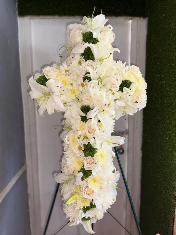 Cruz fúnebre de lirios blancos, rosas crema y margaritas