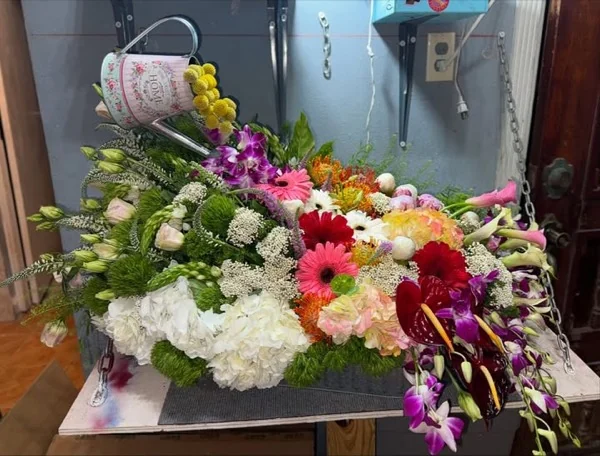 Mesa de trabajo real del taller de Alvit con arreglo de gerberas, orquídeas y hortensias en proceso
