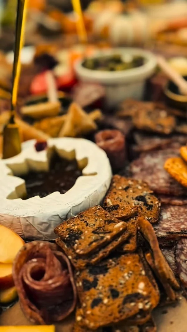 Tabla de charcutería con quesos, embutidos y crackers artesanales