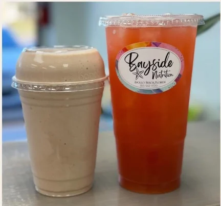 Cream-colored meal replacement shake next to an iced orange loaded tea