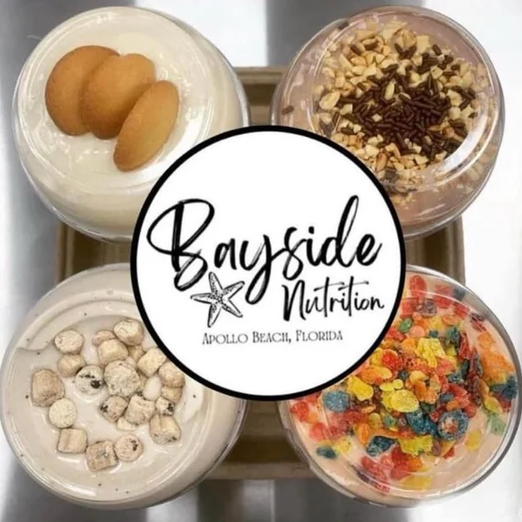 Four meal replacement shakes seen from above, topped with wafer cookies, chopped nuts and chocolate sprinkles, cookie pieces, and fruity cereal