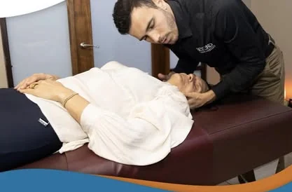Doctor realizando un ajuste cervical a un paciente en la camilla