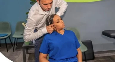 Quiropráctico ajustando el cuello de una paciente sentada