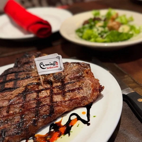 Bife a la parrilla con el banderín de Caminito