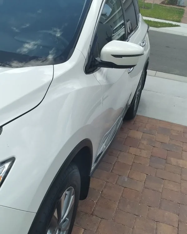 Nissan Rogue blanco reflejando el cielo