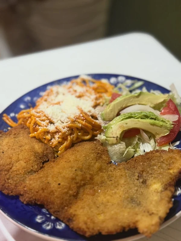 Milanesa empanizada con espagueti rojo y ensalada