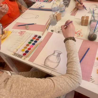 Participante adulta dibujando un bodegón con acuarelas en un taller de Educanvas