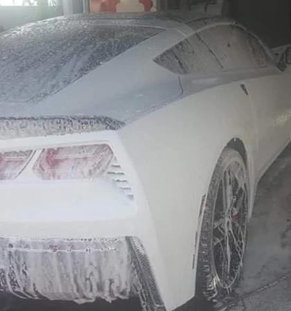 Corvette cubierto completamente en espuma durante el lavado en foam