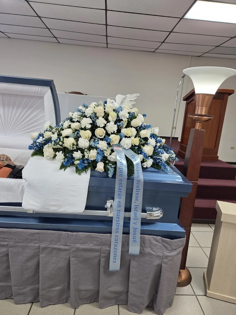 Arreglo funerario en blancos con cintilla impresa elegante, realizado por Floristería Flores Del Parque