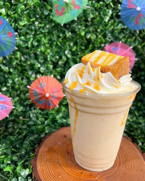 Frappé con crema batida y un trozo de bizcocho encima