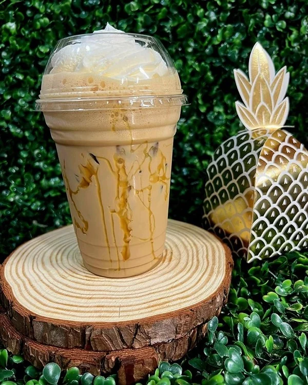 Frappé con sirop de caramelo y tapa de domo sobre base de madera