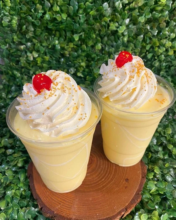 Dos frappés claros con crema batida y cereza encima