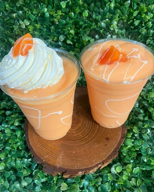 Dos frappés de fruta con crema batida y sirop encima