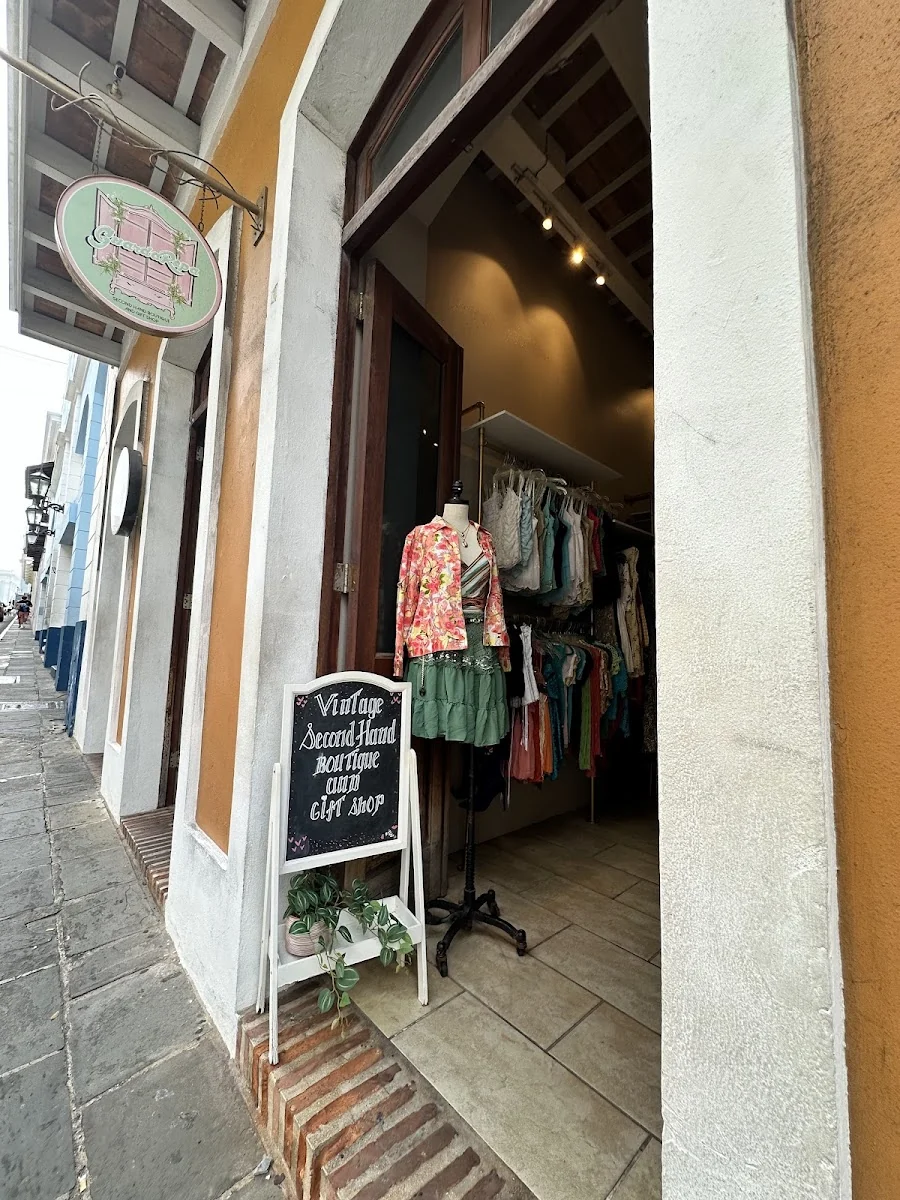 Entrada de GuardaRopa con maniquí vestido de vintage y pizarra que lee Vintage Second Hand Boutique and Gift Shop