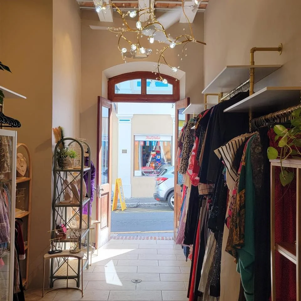 Interior de GuardaRopa: lámpara dorada de cristales, racks de ropa vintage y la puerta abierta hacia la Calle San Francisco