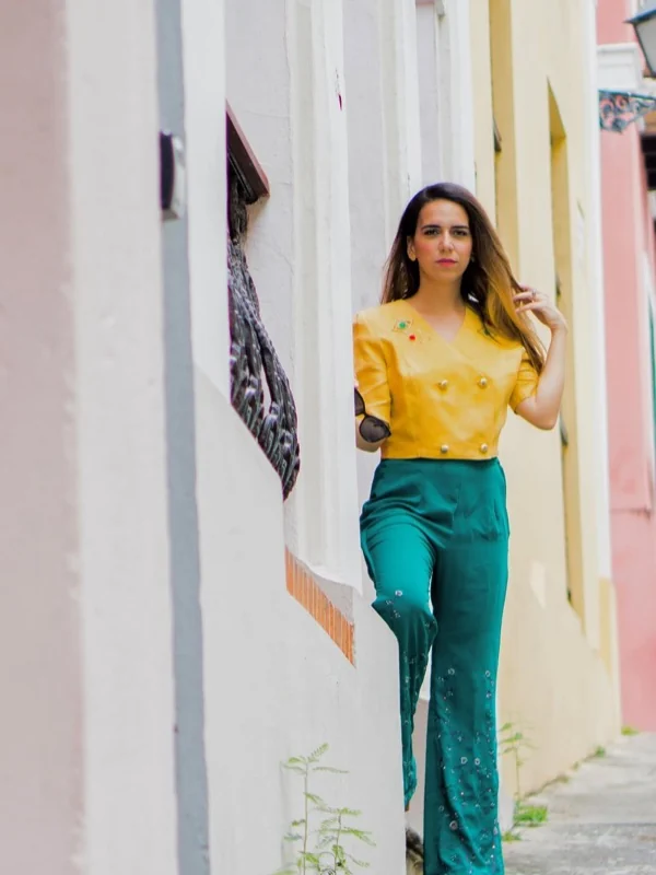 Top mostaza con botones dorados y pantalón esmeralda en una calle empedrada del Viejo San Juan