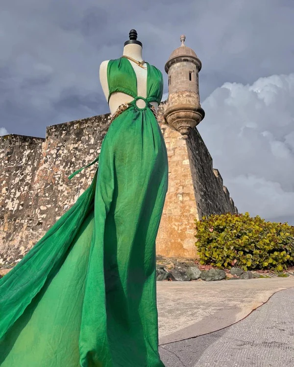Vestido verde esmeralda en maniquí frente a la garita del Morro bajo un cielo dramático
