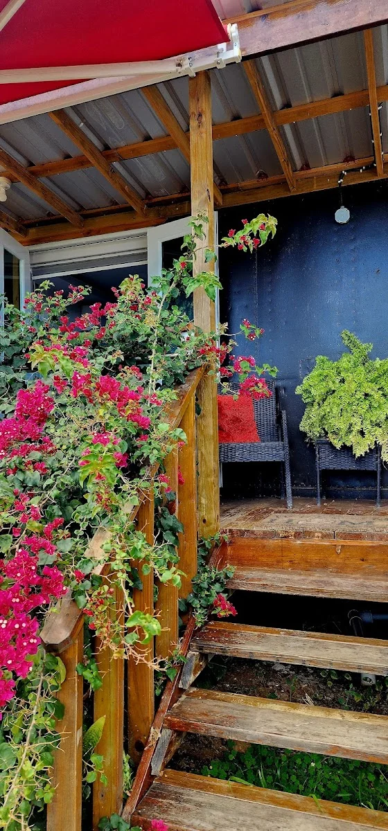 Trinitarias rojas trepando las escaleras de madera de una cabaña en Hacienda Nereyda