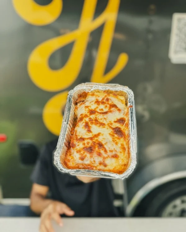 Pizza en bandeja frente al food truck