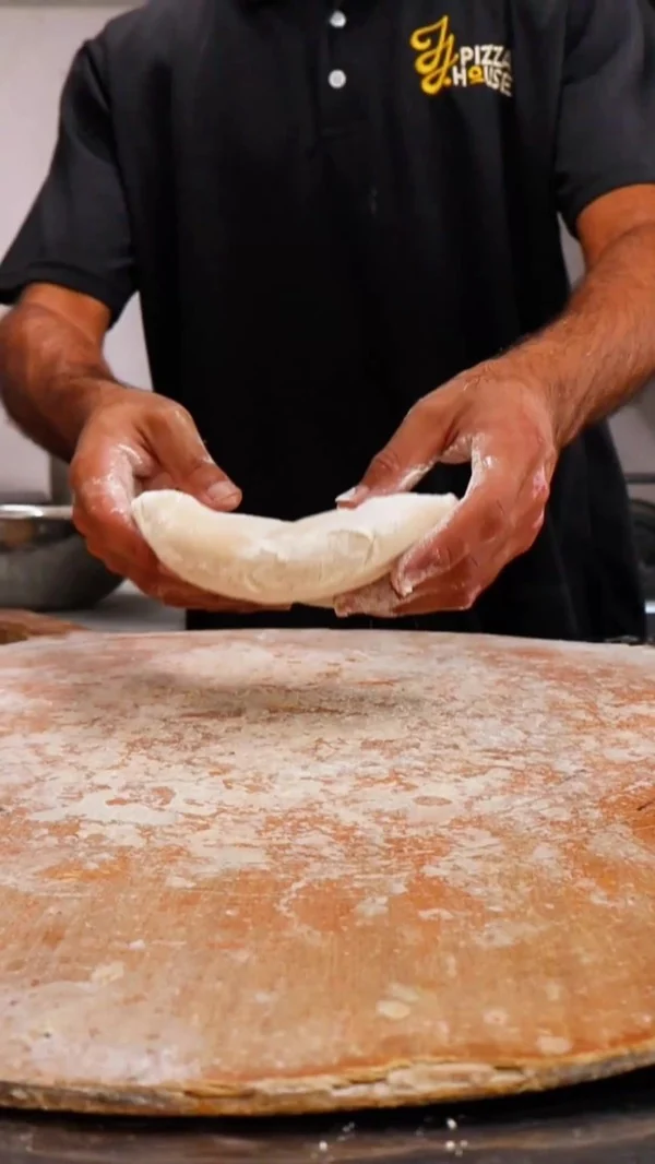 Manos estirando la masa de pizza a mano
