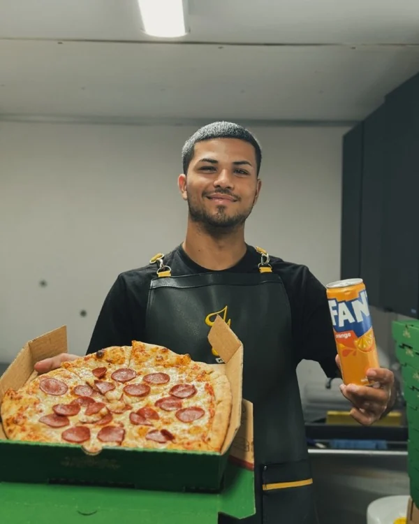 Miembro del equipo sosteniendo una bandeja de pizza