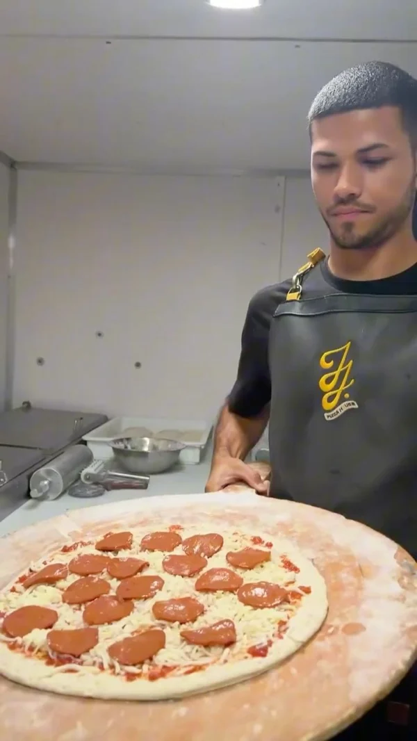 Miembro del equipo presentando la pizza en la pala