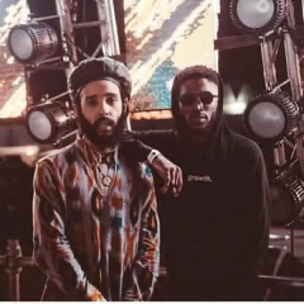 Dos personas frente a luces de tarima, una con hoodie JUNZI negro