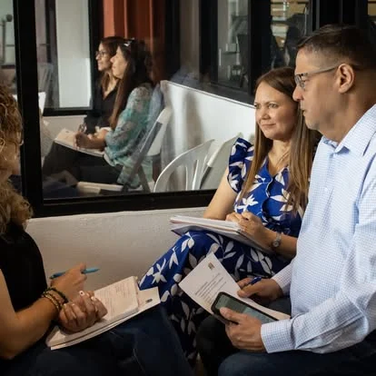 Consulta legal con el Lcdo. Osuna revisando documentos con clientes en Caguas