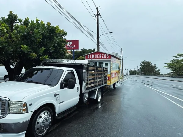Camión remolcando el trailer de la lechonera por la carretera