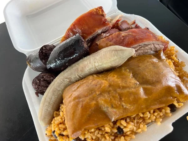 Almuerzo con lechón, cuerito crujiente, morcilla, guineo y pastel