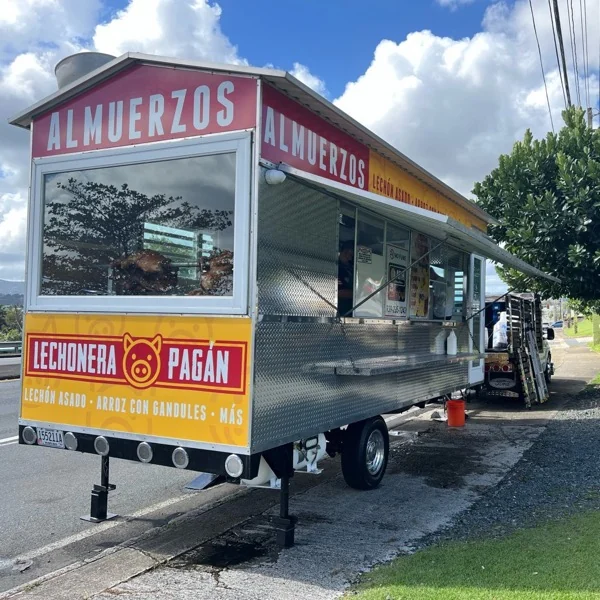 Trailer de Lechonera Pagán estacionado en la carretera con el lechón en la ventana