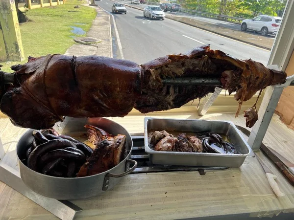 Lechón entero al asador con las morcillas en la bandeja