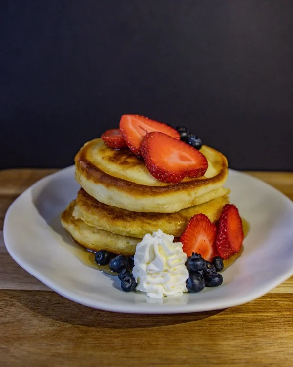Pancakes con fresas, arándanos y crema batida