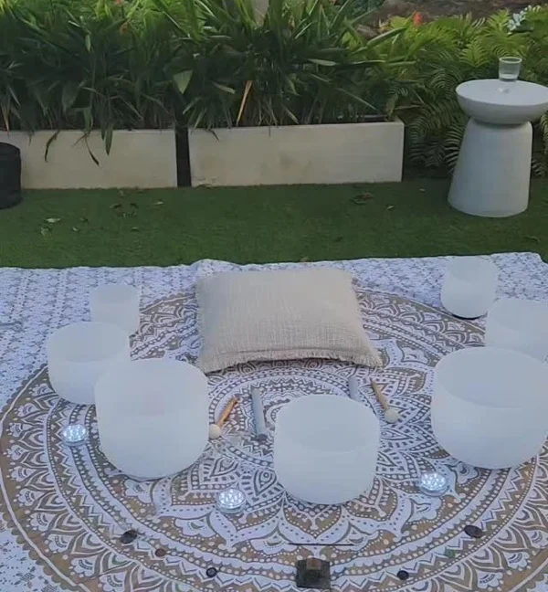 Cuencos de cuarzo dispuestos en círculo sobre un mandala al aire libre