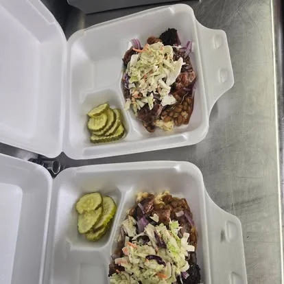 Dos cajas de BBQ con slaw, baked beans y pickles