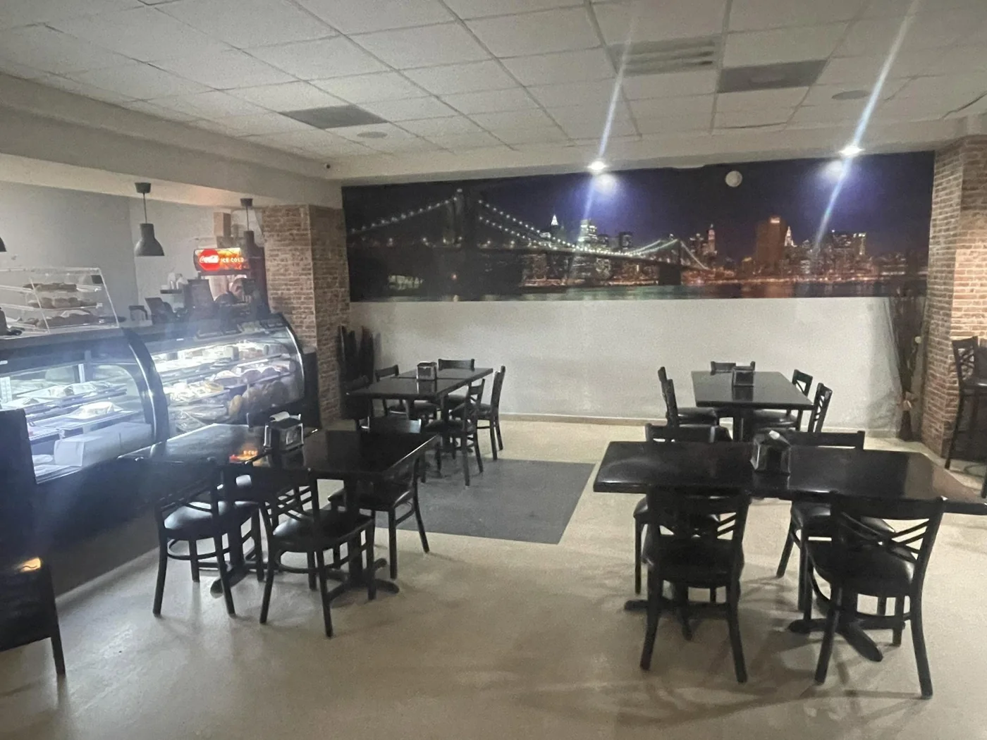 Interior de New York Deli Cuisine con mural del skyline de Nueva York