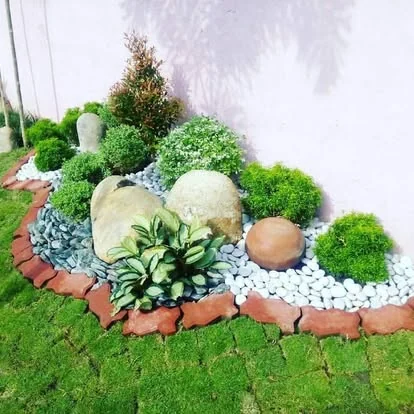 Jardín decorativo con moss, borde de ladrillo, boulders y suculentas