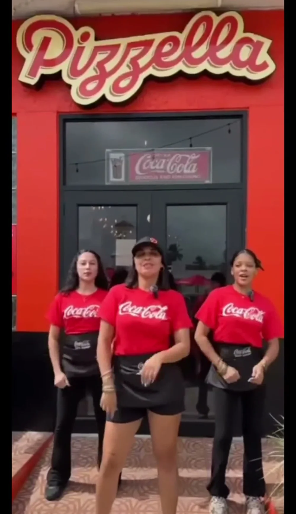 Fachada de Pizzella con su rótulo rojo y el equipo