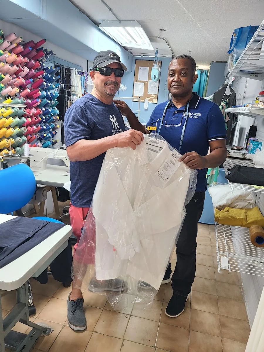 Cliente recibiendo su prenda terminada y enfundada en Sastrería Santos
