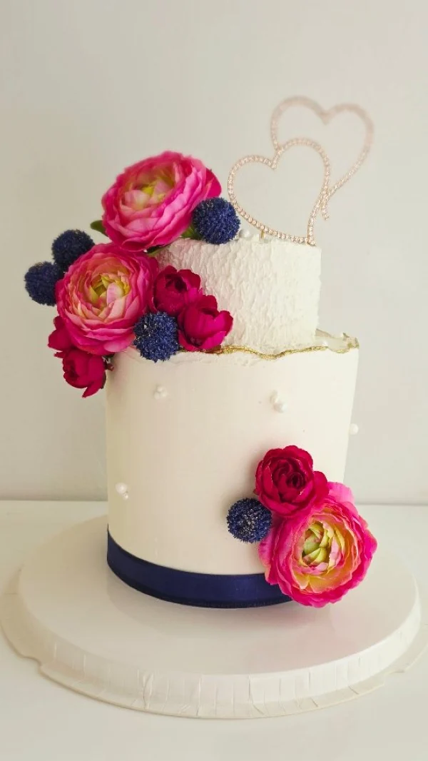 Cake floral con ranúnculos fucsia y cinta marina