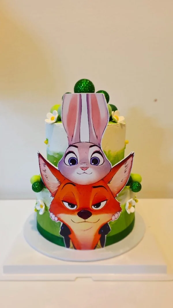 Cake de dos pisos con personajes animados y esferas verdes