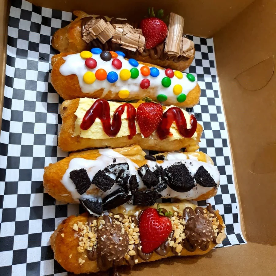 Palitos de hojaldre con toppings de chocolates, fresas y galleta