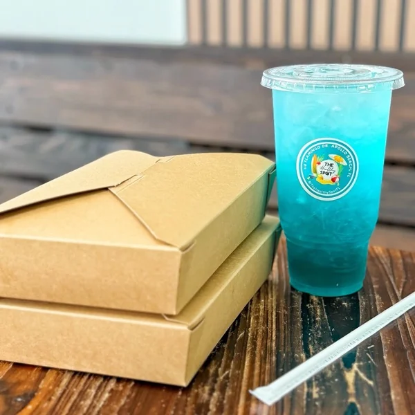 Dos cajas kraft de comida para llevar junto a un vaso azul de The Healthy Spot